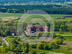 Tykocin castle on sunny day surrounded with green meadows and trees