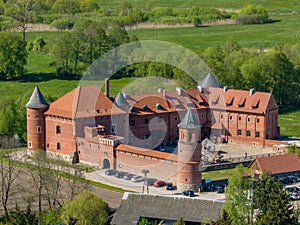 Tykocin castle on sunny day surrounded with green meadows and trees