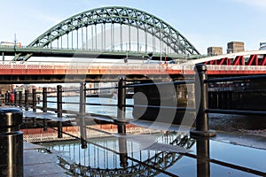 Tyne Bridge on Newcastle Quayside with reflection in puddle after rainstorm