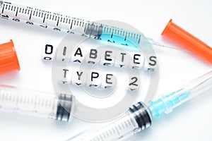 Type 2 diabetes text spelled with plastic letter beads placed next to an insulin syringe