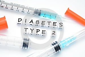 Type 2 diabetes text spelled with plastic letter beads placed next to an insulin syringe