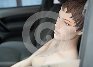 Type topless mannequin in the window of a passenger car