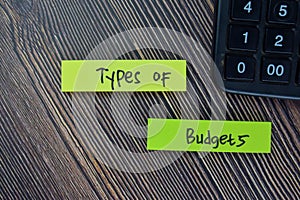 Types of Budgets write on sticky notes isolated on Wooden Table