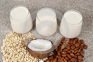 Types of plant-based milk in glasses. Oat, coconut and almond milk.