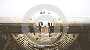 Typewriter and empty white paper with a word Dear, vintage style