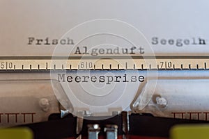 Typewriter with a leaf and the words Frisch, Seegeln, Algenduft und Meeresprise Fresh,  Sail, Algenduft and Meeresprise