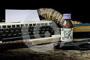 Typewriter with paper page and poison and gun.