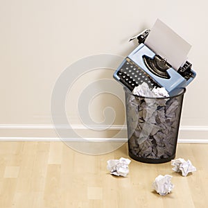 Typewriter in trash can.