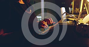 Typewriter, woman hands and night working of a creative writer in a office with book. Journalist, female worker and