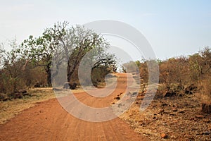 A typical African road in the countryside is dry red earth