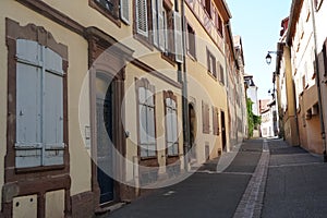 Typical Alsatian architecture in a narrow street in Colmar, France paved with cobblestones. The houses are properly maintained and