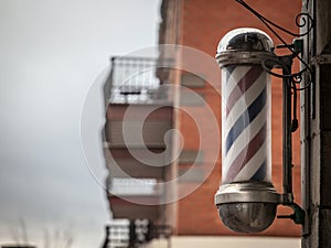 Typical American barbers pole seen in front of a barber shop of Montreal, Canada.