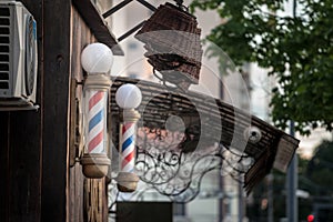 Typical American barbers pole seen in front of a barber shop. This pole is a vintage sign indicating presence of male hairdresser