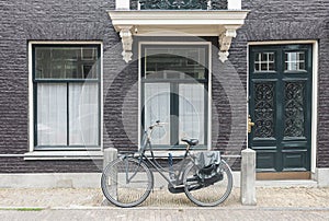 Typical Amsterdam street view in Netherlands with old doors and windows and vintage bicycle