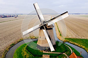 Typical ancient Dutch windmill with fields from above
