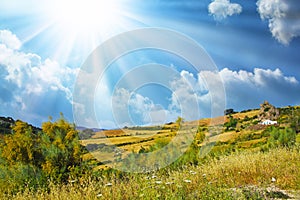 Typical andalusian calm mountain valley landscape, sun rays, low morning clouds, idyllic white farm house in rock front,