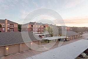 Typical apartment complex with detached garage and covered parking lots at sunrise