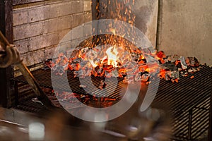 Typical Argentinian barbecue or asado. Burning wood in the grill and red hot coals