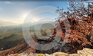 Typical autumn landscape. Hills and villages with foggy fall valley