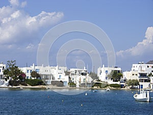 typical beach community with Cyclades style white house blue door Pollonia Milos Greece