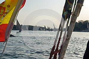 Typical boats of the Nile river called felucca seen from one of them with the Spanish flag