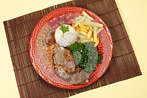 Typical Brazilian basic dish with rice, beans, steak, french fries, braised cabbage and tomato