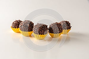 Typical brazilian brigadeiros, isolated on white background and yellow mold photo