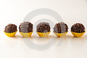 Typical brazilian brigadeiros, isolated on white background and yellow mold photo