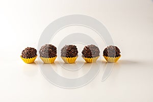 Typical brazilian brigadeiros, isolated on white background and yellow mold photo