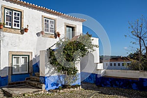 Typical brightly colored blue and white building in Obidos Portugal, a stonewalled city in a castle