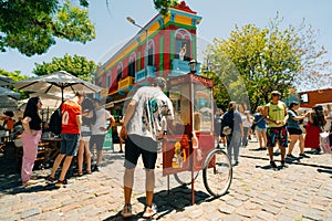 Typical brightly colored building on Caminito in La Boca witn tourists, Buenos Aires, Argentina - dec 2th 2023