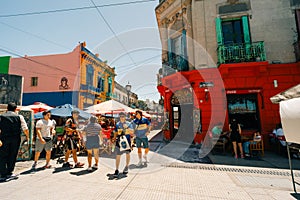 Typical brightly colored building on Caminito in La Boca witn tourists, Buenos Aires, Argentina - dec 2th 2023