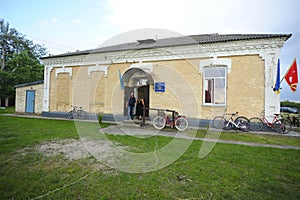 Typical building of a rural House of Culture in Ukrainian villages, national flags flying