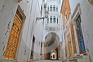 Typical cobbled and narrow alley viewed from Pacha street with colorful doors, columns and arcades