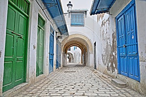 Typical cobbled and narrow street Pacha street with colorful doors, columns and arcades