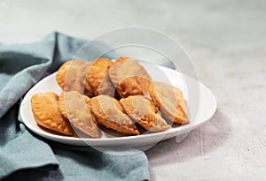 Typical Colombian empanadas usually served with spicy sauce on concrete surface