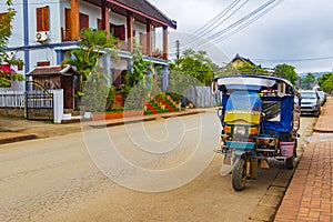 Typical colorful old tuk tuk rickshaw in Luang Prabang Laos