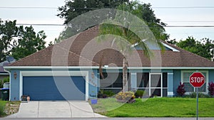 Typical contemporary american private house in Florida with roof top covered with asphalt shingles, wide garage door and