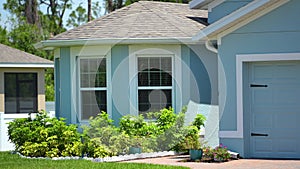 Typical contemporary american private house in Florida with roof top covered with asphalt shingles, wide garage door and