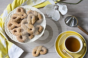 Typical cookies from The Netherlands called Krakeling, with cup of tea and flower