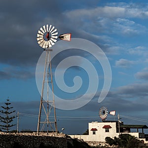 typical cottage and wind wheels in the countryside of Malta in warm evening light