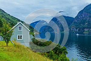 Typical countryside Norwegian landscape with green wall house. Cloudy summer morning in Norway, Europe.