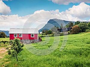 Typical countryside Norwegian landscape with red painted wall house. Picturesque summer morning in Norway, Europe. Beauty of