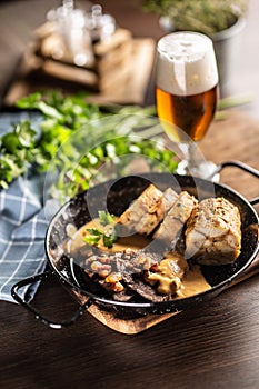 Typical Czech food svickova na smetane with dumplings and a draft pilsener beer in a glass