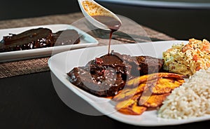 Typical dish of black roasted venezuela with chicken salad and banana photo