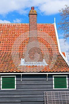 A typical Dutch house with red roof tiles and a brick mantelpiece