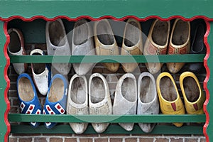 Typical Dutch image of old used clogs in a wooden rack