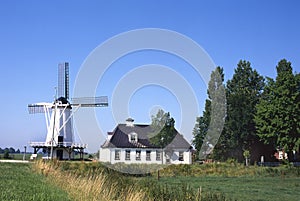 Typical dutch landscape with farm and windmill