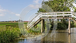 Typical Dutch landscape with an old wooden bridge and modern win