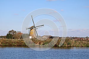 Typical dutch scene of a mill next to the water in holland